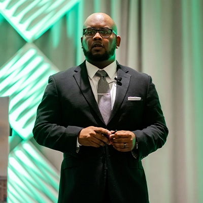 Charles T. Brown, wearing a suit, stands on a stage.