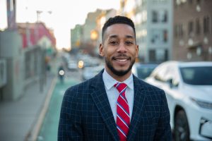 Antonio Reynoso stands smiling in a bike lane